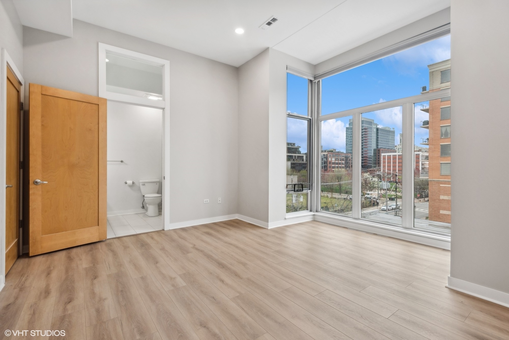 939 West Madison Street, Unit 410 Chicago, IL 60607 - Photo 13 of 23 a view of an empty room with wooden floor and a window
