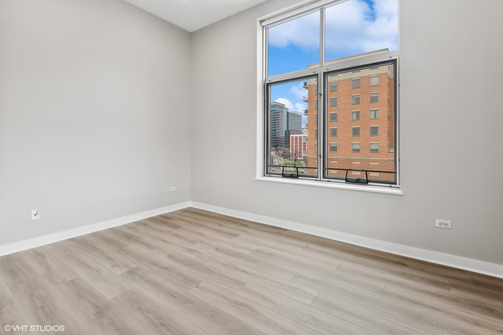 939 West Madison Street, Unit 410 Chicago, IL 60607 - Photo 16 of 23 an empty room with wooden floor and windows