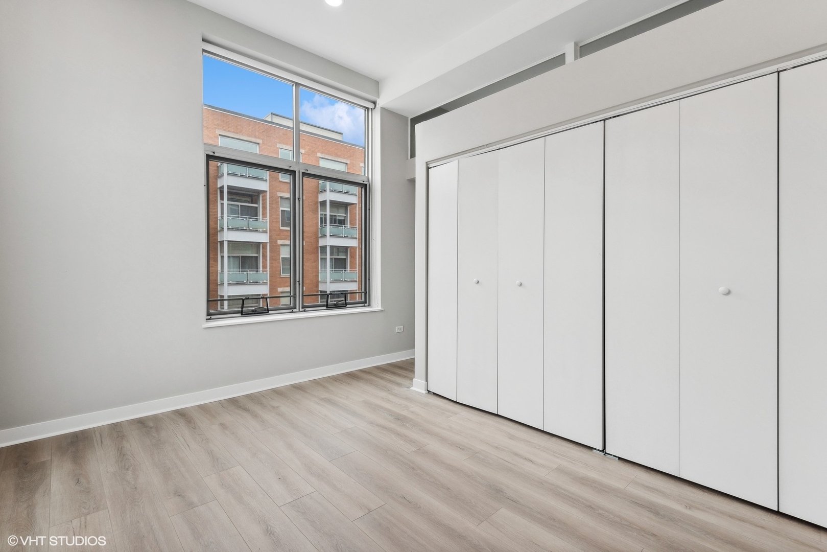 939 West Madison Street, Unit 410 Chicago, IL 60607 - Photo 18 of 23 a view of an empty room with window and wooden floor