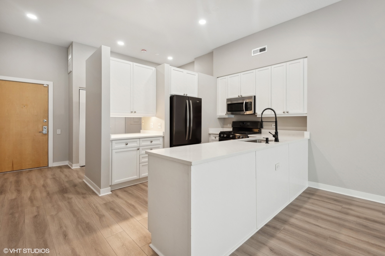 939 West Madison Street, Unit 410 Chicago, IL 60607 - Photo 6 of 23 a kitchen with a refrigerator a stove top oven and white cabinets