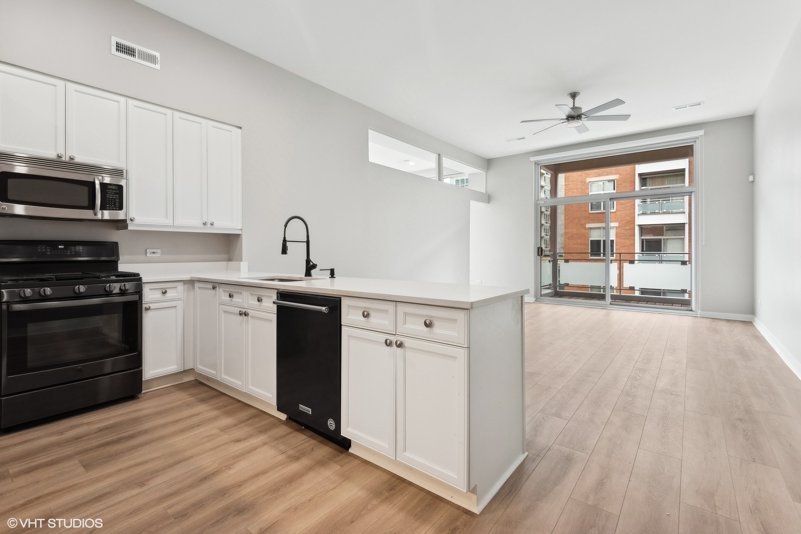 939 West Madison Street, Unit 410 Chicago, IL 60607 - Photo 8 of 23 a kitchen with granite countertop a stove a sink and a refrigerator