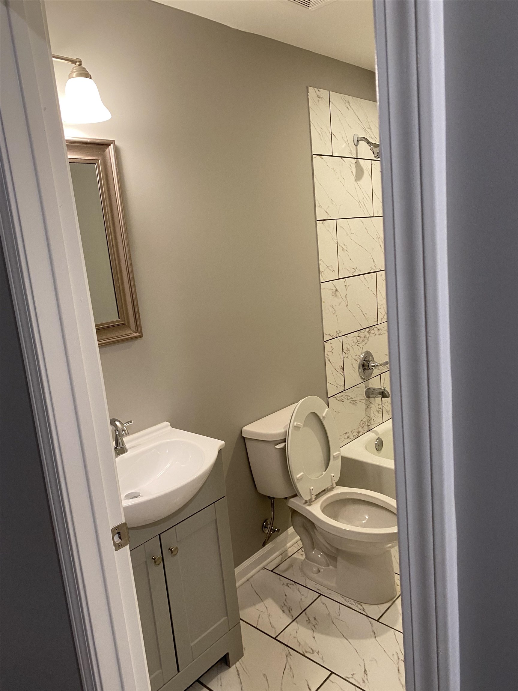 1729 Hanson Road Memphis, TN 38108 - Photo 10 of 12 a white toilet sitting next to a bathroom sink