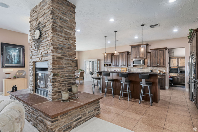 2376 Stone Crest Circle St. George, UT 84790 - Photo 9 of 61 Living area featuring light tile patterned floors, a fireplace, recessed lighting, and a textured ceiling