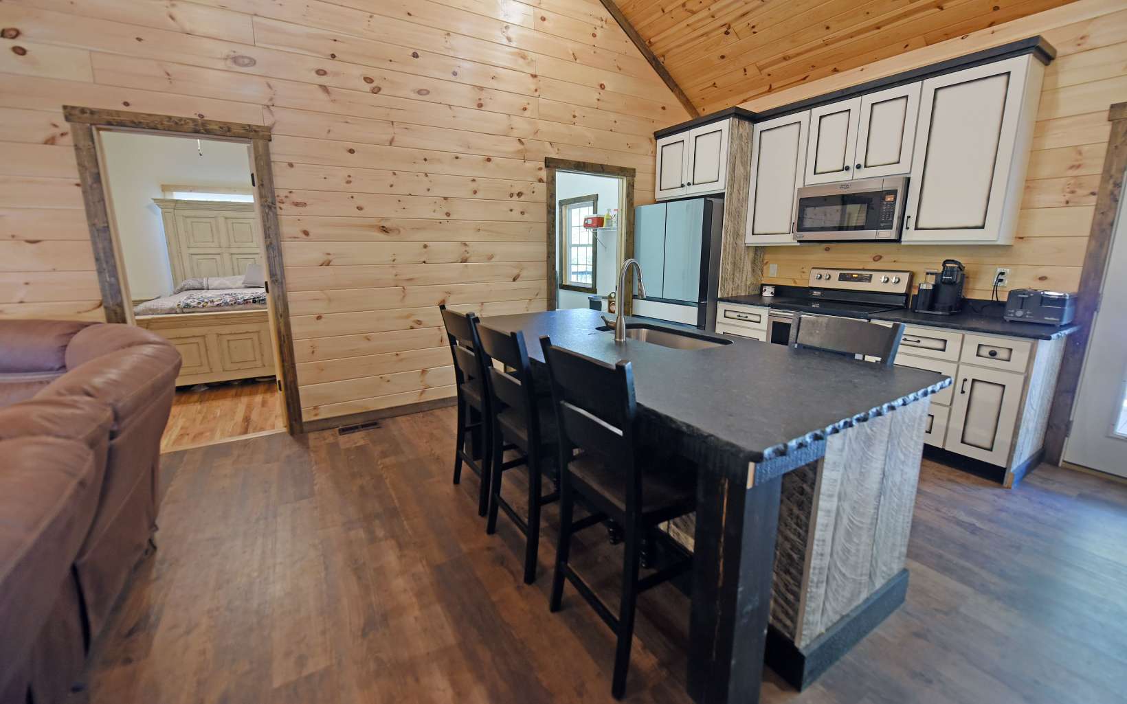 110 Goldfinch Lane Murphy, NC 28906 - Photo 8 of 36 a kitchen with stainless steel appliances granite countertop a stove a refrigerator a sink a dining table and chairs with wooden floor