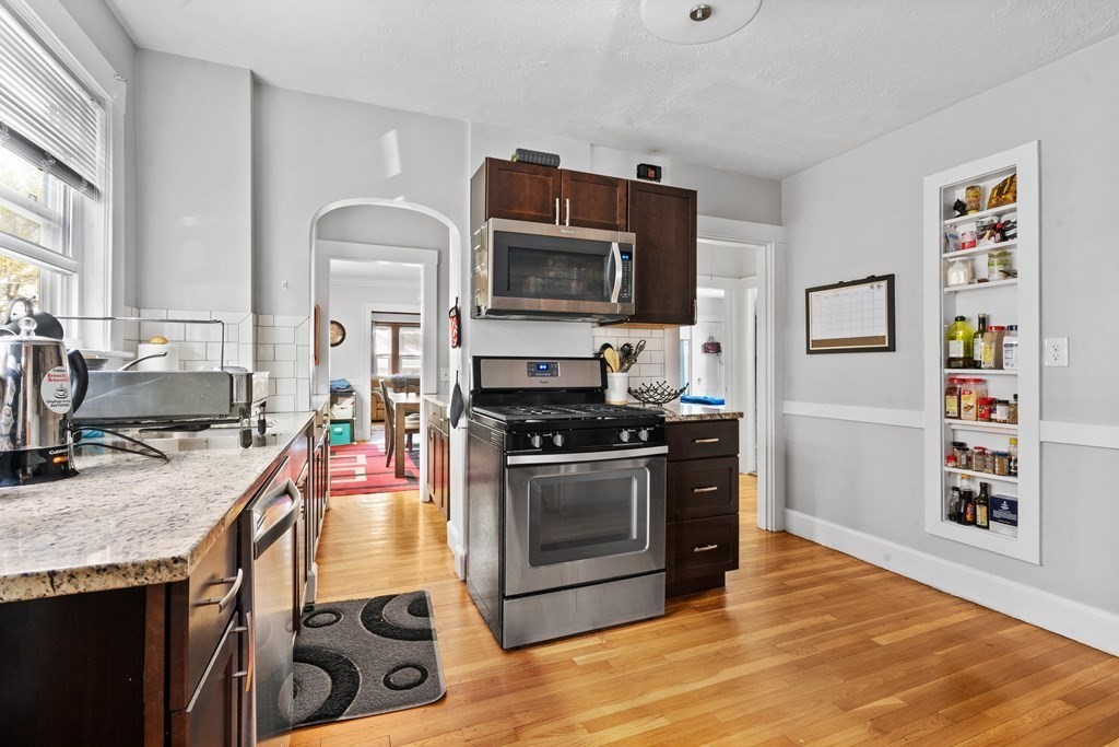 28 Warwick Road, Unit 1 Watertown, MA 02472 - Photo 3 of 12 a kitchen with stainless steel appliances granite countertop a stove a sink and a microwave