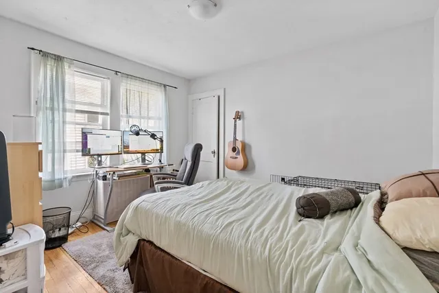 a bedroom with a bed and large windows
