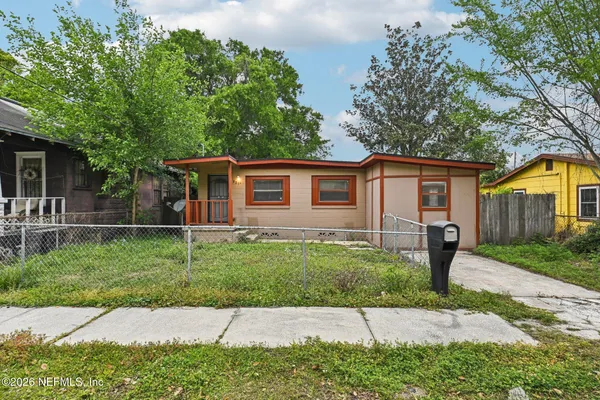 a front view of a house with a garden and trees