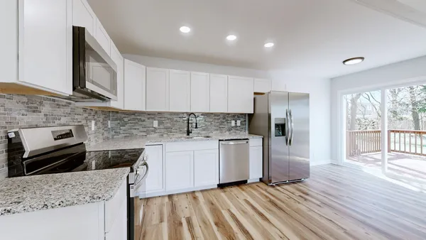 a kitchen with stainless steel appliances granite countertop a stove a sink and a refrigerator