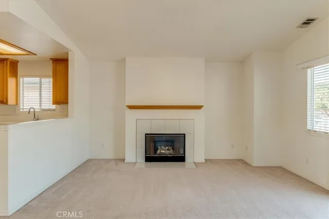 an empty room with windows and fireplace