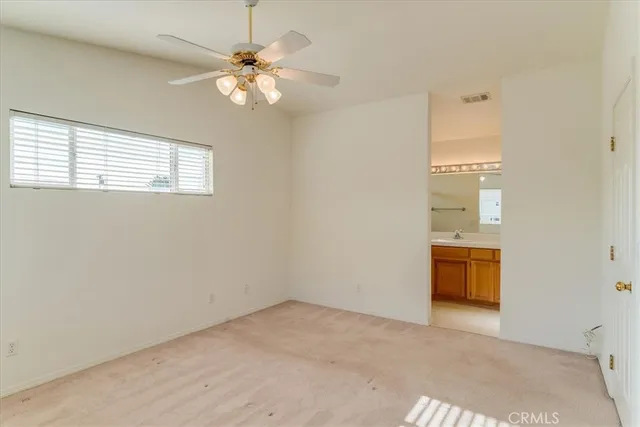 an empty room with a window and a ceiling fan
