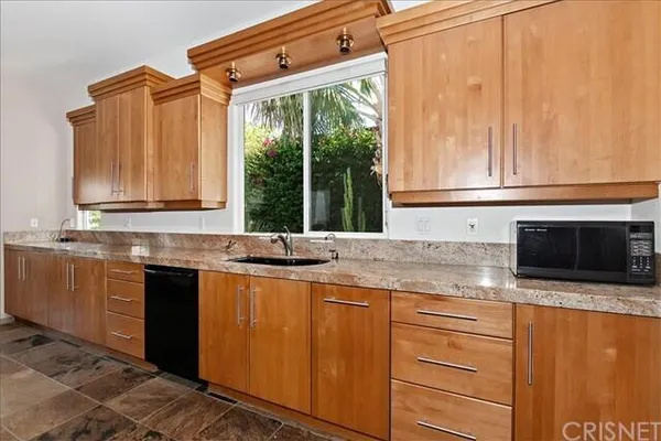 a kitchen with stainless steel appliances granite countertop a sink and a microwave
