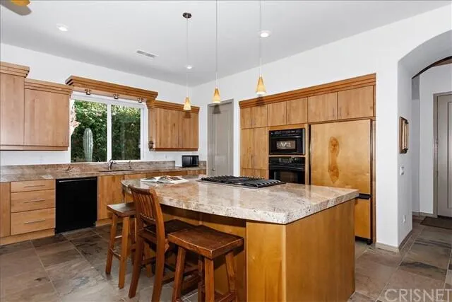 a kitchen with stainless steel appliances granite countertop sink stove and refrigerator