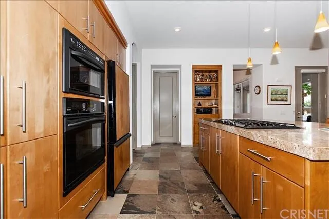 a kitchen with stainless steel appliances granite countertop a refrigerator and a stove top oven