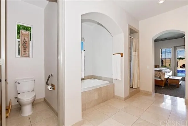 a spacious bathroom with a tub and toilet