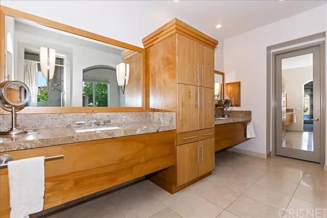 a bathroom with a granite countertop sink and a mirror