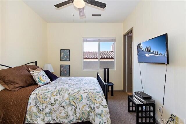 69707 Camino Pacifico Rancho Mirage, CA 92270 - Photo 26 of 38 a bedroom with a bed and a chandelier