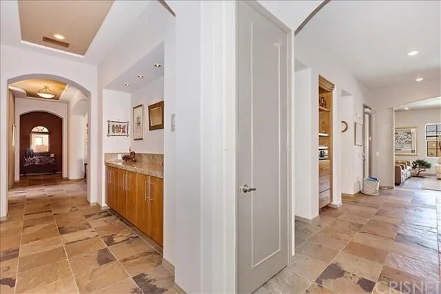 a view of a hallway with bathroom and mirror