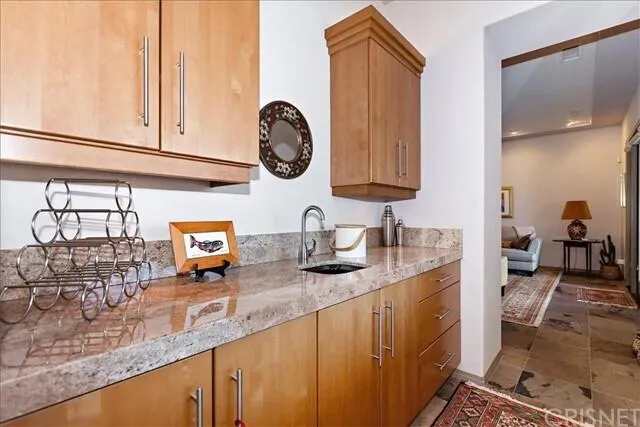 a kitchen with granite countertop a sink a stove and cabinets