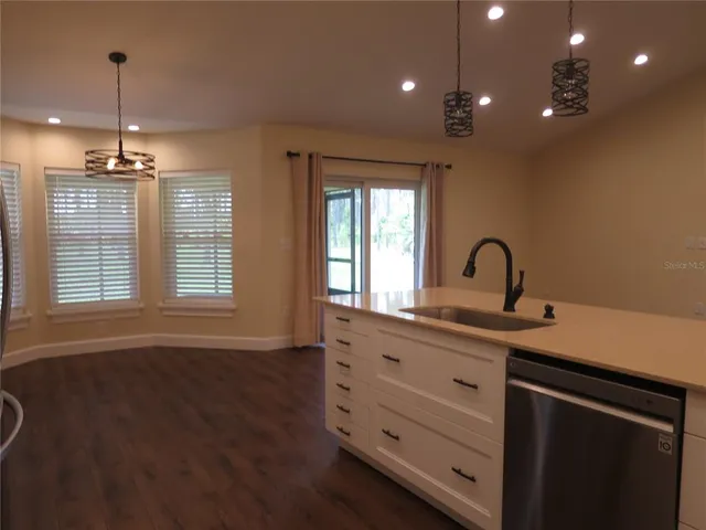 a room with stainless steel appliances kitchen island a large island in the center