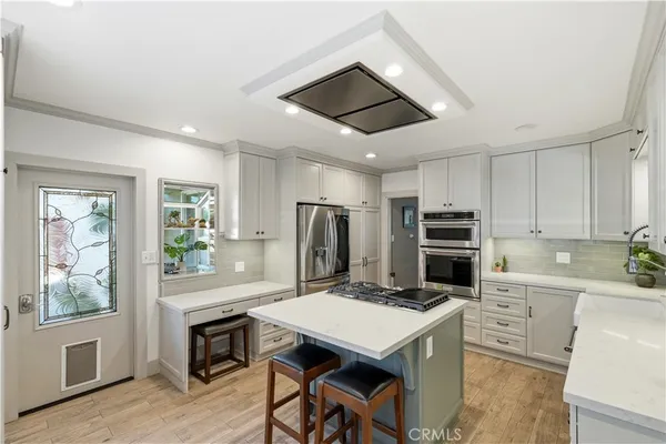 a kitchen with stainless steel appliances a stove a refrigerator and a kitchen island