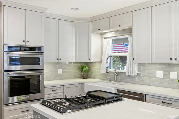a kitchen with granite countertop a stove sink and cabinets