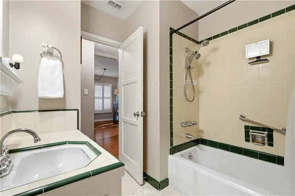 a bathroom with a tub sink shower and mirror