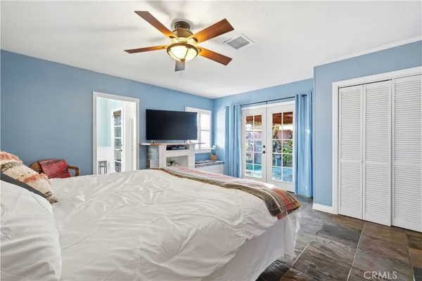 a spacious bedroom with a bed and a flat tv screen