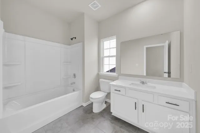 a bathroom with a double vanity sink toilet and bathtub