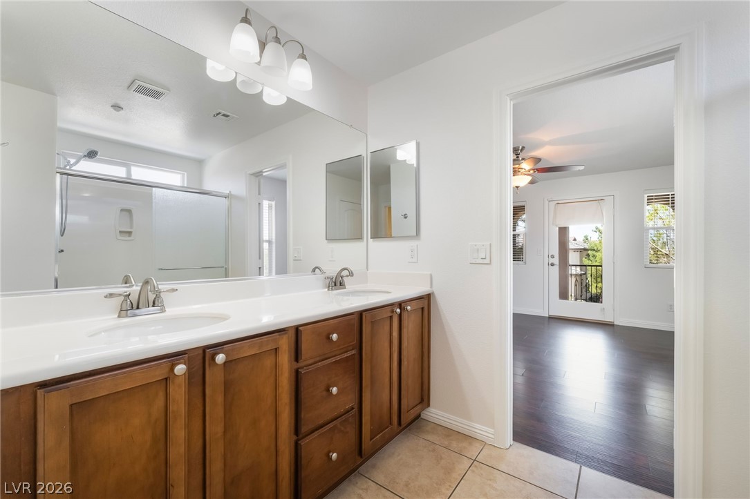 3175 Via Seranova Henderson, NV 89044 - Photo 24 of 45 This primary bathroom offers dual sinks, a spacious shower, and elegant tile flooring.