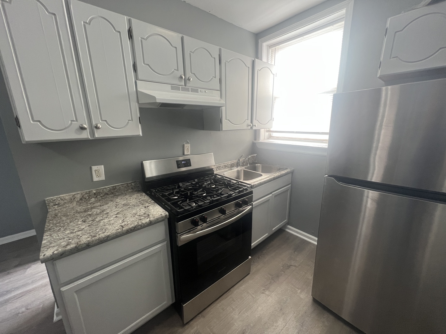 239 East 108th Street, Unit 2 Chicago, IL 60628 - Photo 4 of 7 a kitchen with stainless steel appliances granite countertop a refrigerator sink and stove