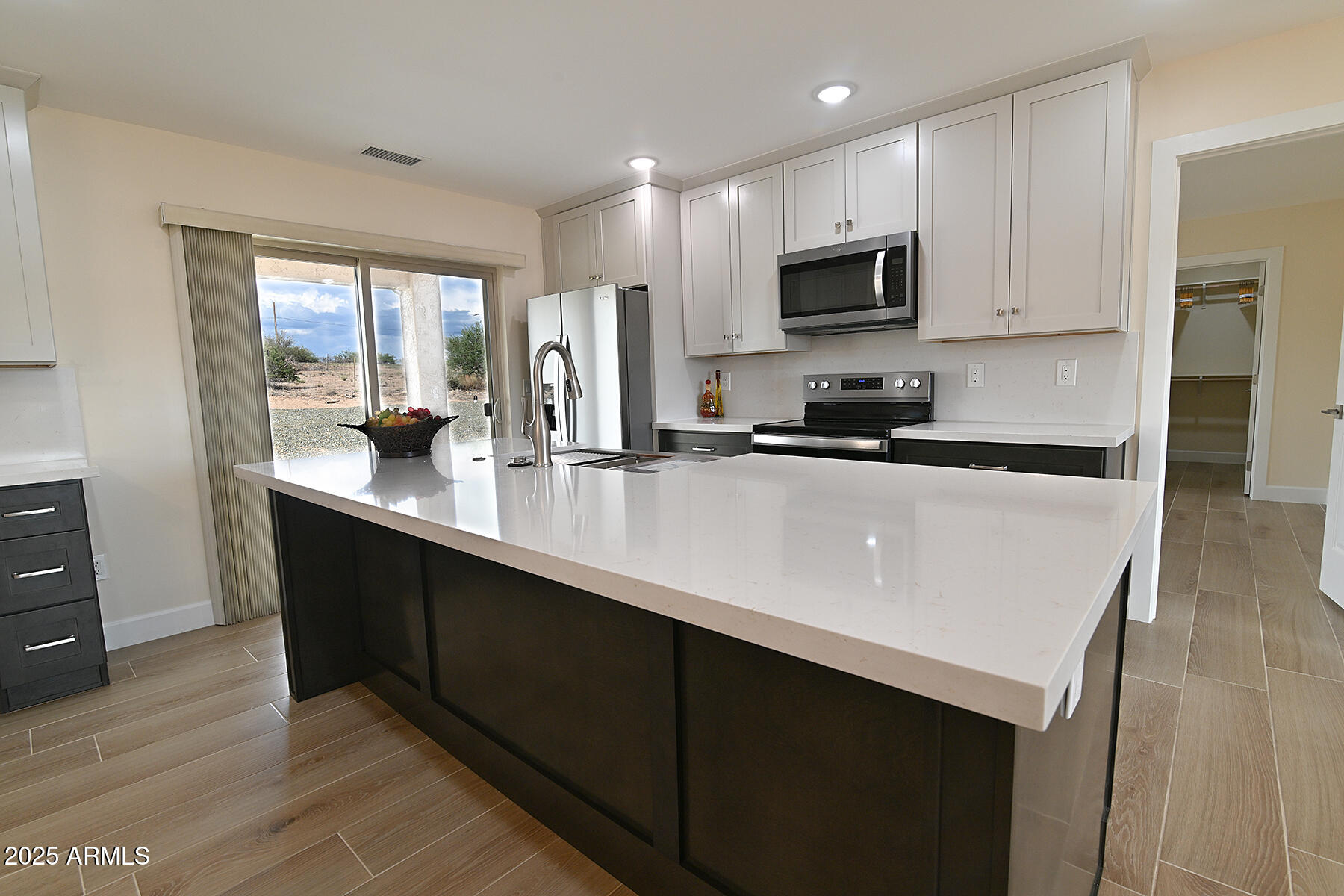 20214 East Mesa Verde Road Mayer, AZ 86333 - Photo 4 of 26 a kitchen with granite countertop a sink and a stove top oven with wooden floor