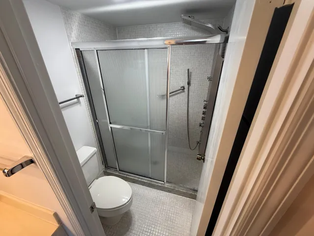 a bathroom with a granite countertop toilet and a sink
