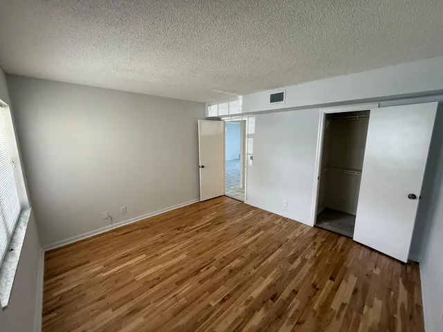 a view of empty room with wooden floor