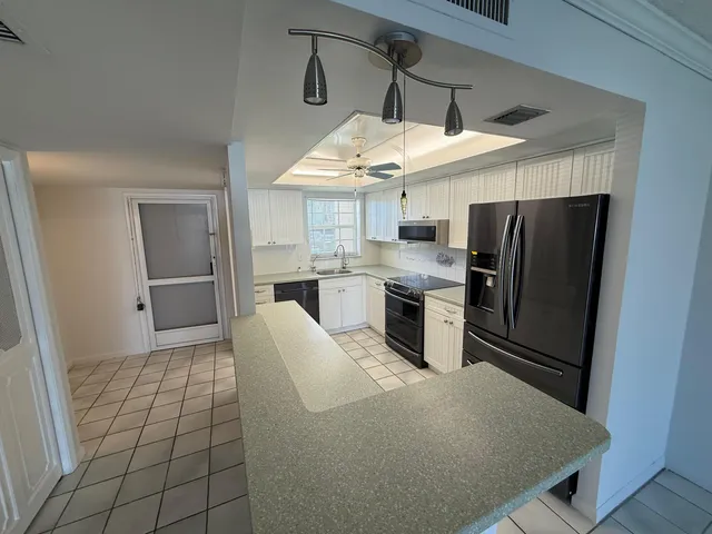a kitchen with stainless steel appliances a stove a refrigerator and a sink