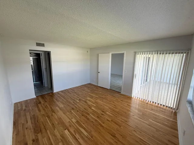 a view of empty room with wooden floor