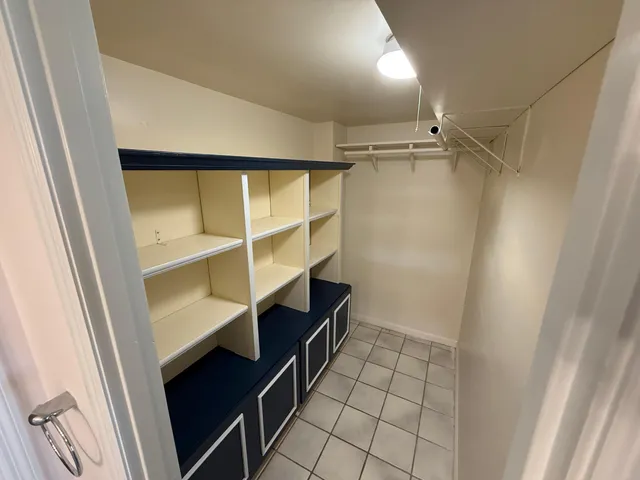a view of walk in closet with empty racks