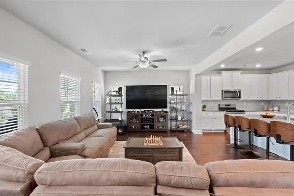 a living room with furniture kitchen view and a flat screen tv