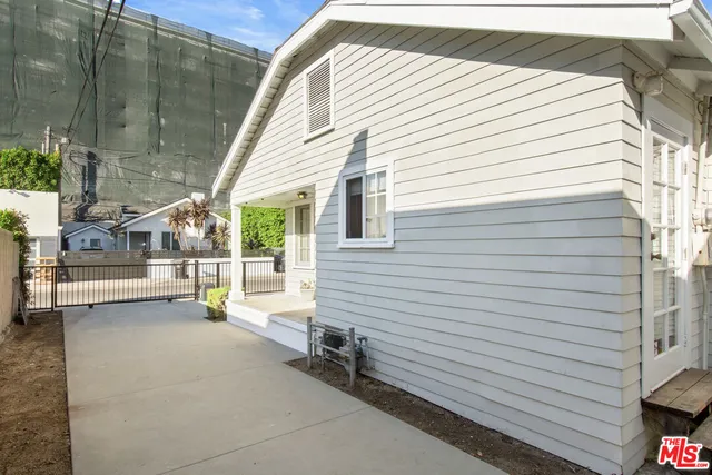 a view of a patio with table and chairs and a barbeque