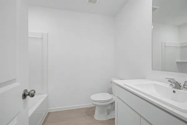 a bathroom with a toilet sink vanity and mirror