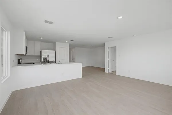 a view of kitchen with kitchen island white cabinets and refrigerator