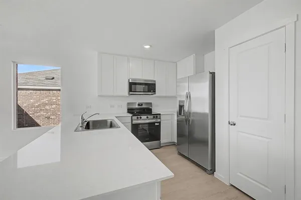 a kitchen with a refrigerator a stove top oven a sink and dishwasher