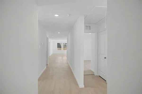 a view of a hallway with wooden floor