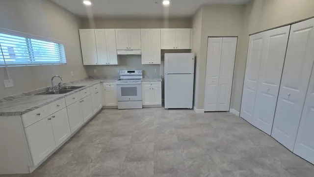 a kitchen with white cabinets and white stainless steel appliances