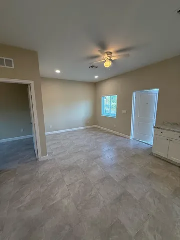 a view of empty room with window and ceiling fan