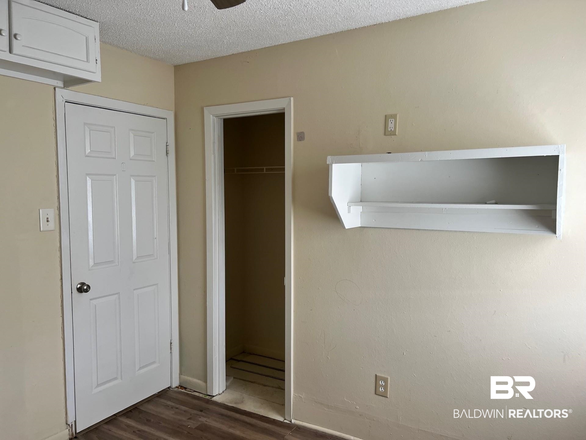 72 Grimes Lane Loxley, AL 36551 - Photo 10 of 12 Unfurnished bedroom featuring a textured ceiling, a closet, and dark wood finished floors