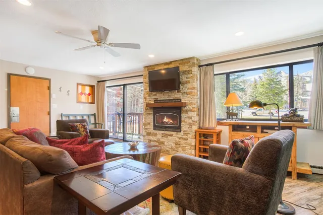 a living room with furniture a flat screen tv and a large window