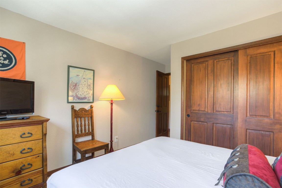 350 4 O Clock Road, Unit C Breckenridge, CO 80424 - Photo 14 of 29 a bedroom with a bed and flat tv screen on the dresser