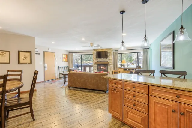 a kitchen with granite countertop a table chairs and wooden floor