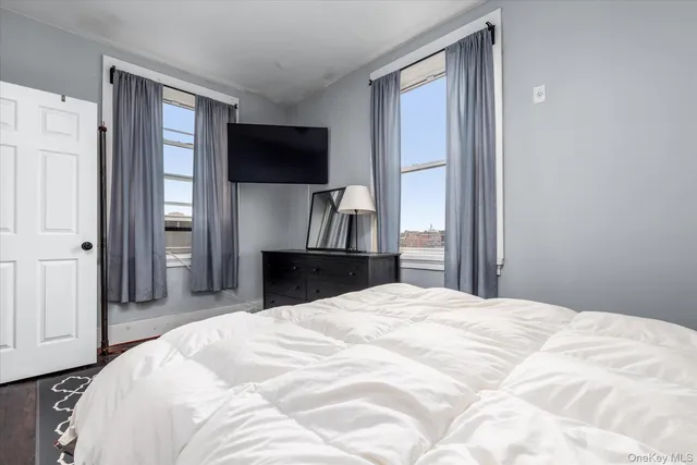 a large bedroom with a bed and a flat screen tv