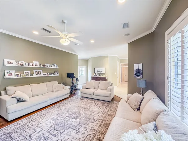 a bedroom with a large bed a chandelier a flat tv screen and next to a window